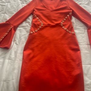 Bright orange stretch dress with fun bell sleeves and gold grommet detail